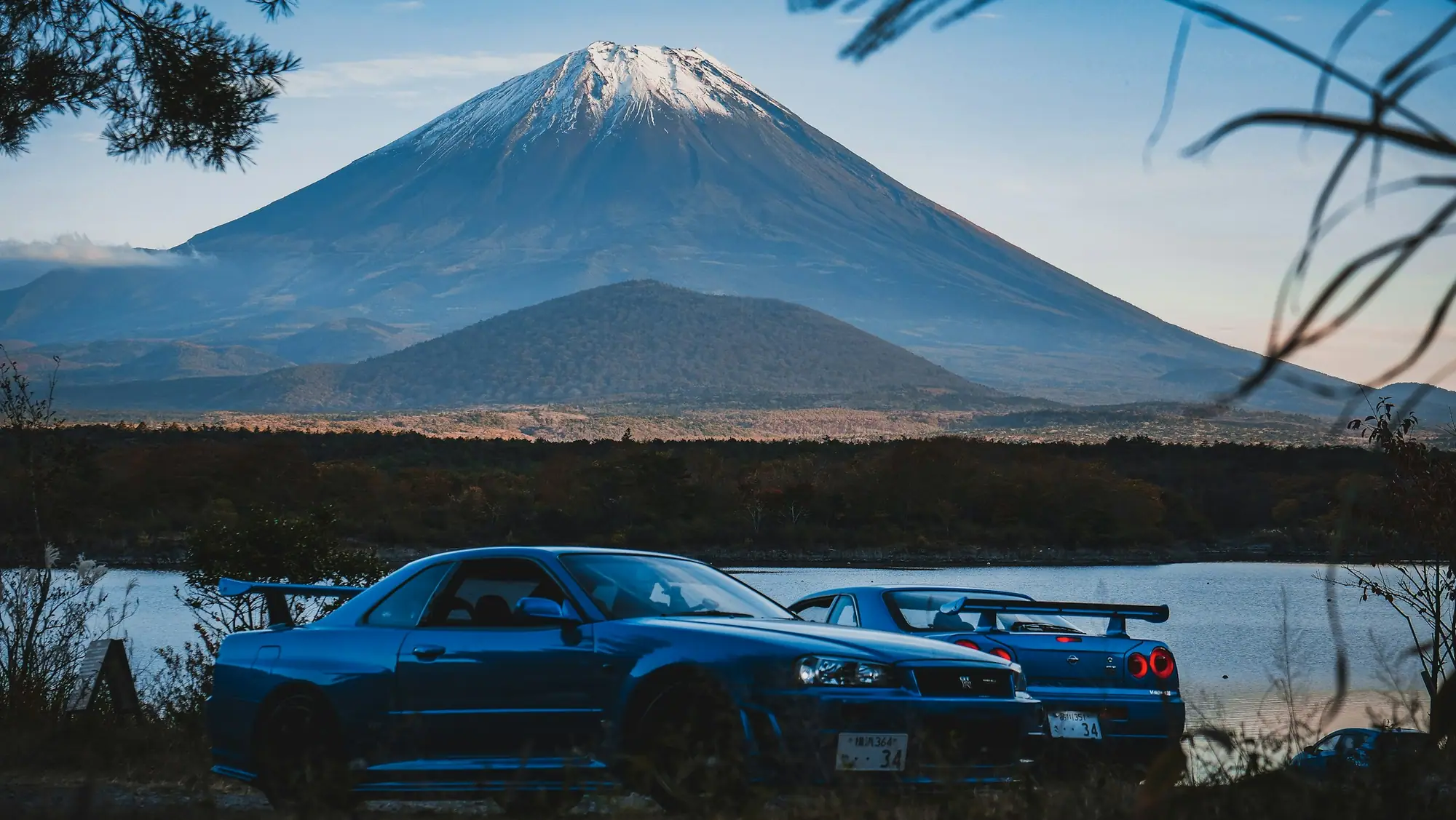 Nissan Skyline GT-Rs parked in front of Mount Fuji